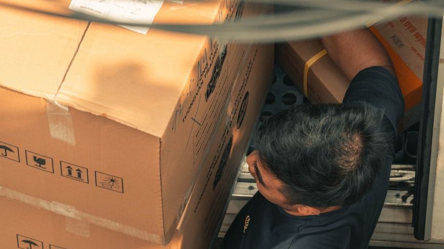 Vero Beach junk removal worker loading a boxed item into the truck