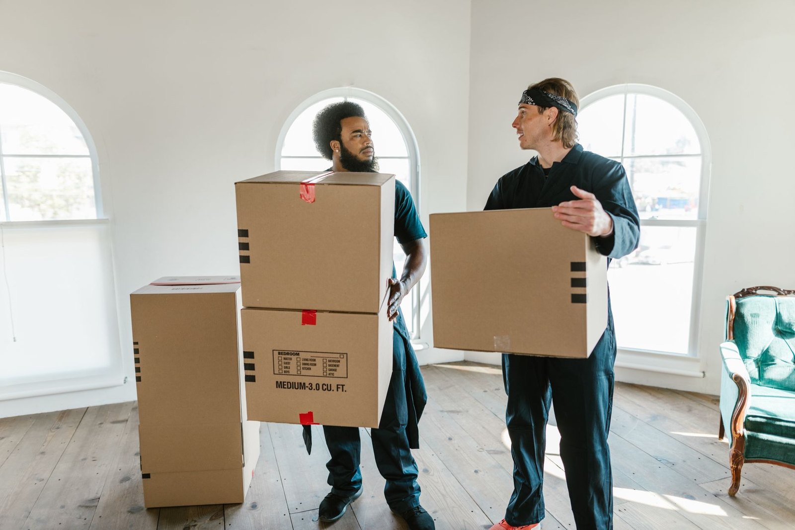 Two-person Vero Beach Junk Removal crew carrying stacked boxes out of a home